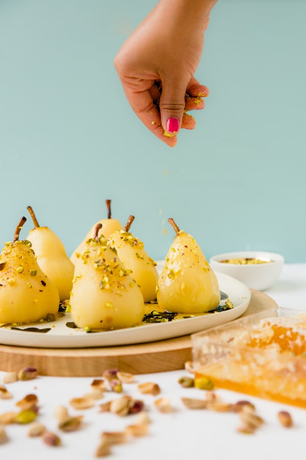 Recipe for boozy poached pears with drizzled honey and pistachios