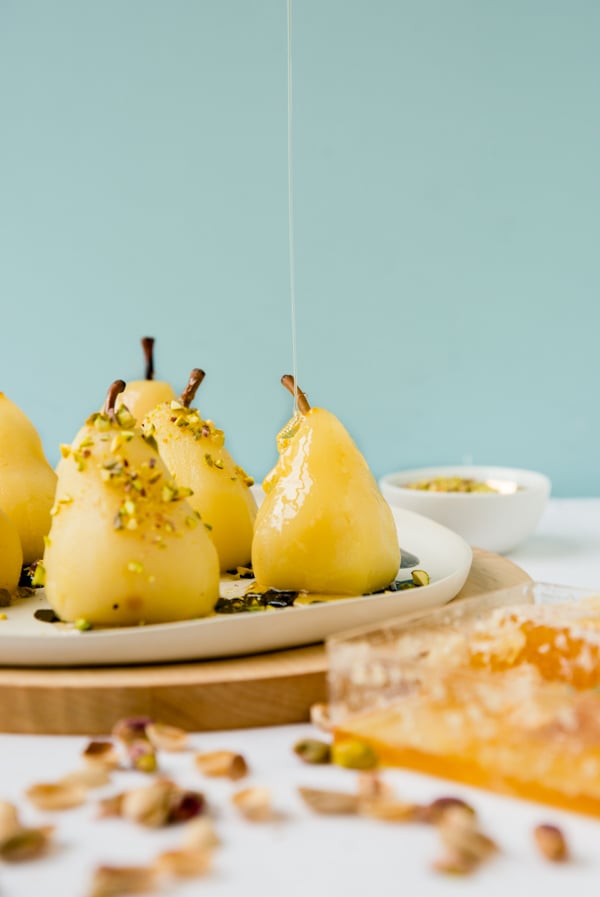 Boozy poached pears with drizzled honey and pistachios