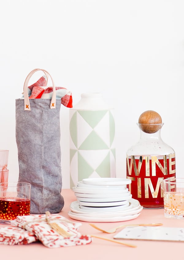 Canvas wine tote sitting on a pink table.