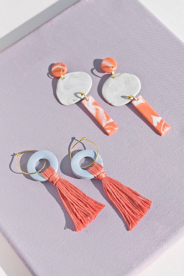 polymer clay earrings in pastel shades laid out next to each other on flat surface