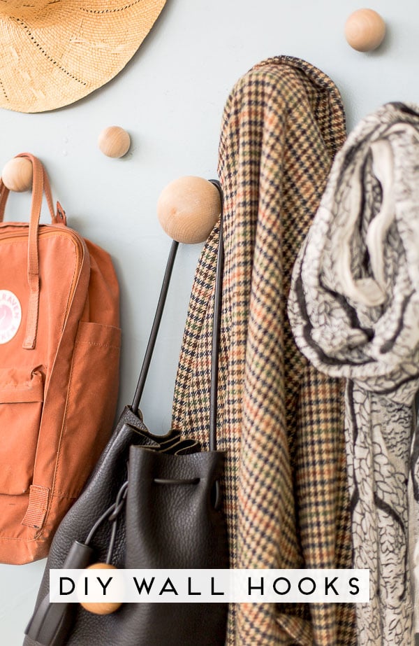 Organize your entryway with these wooden DIY wall hooks. Click through for the step by step tutorial for turning basic blocks and dowel rods into wall hooks in just a few minutes. #wallhooks #diy #tutorial #howto #wood #woodproject #woodworking #organization #organized