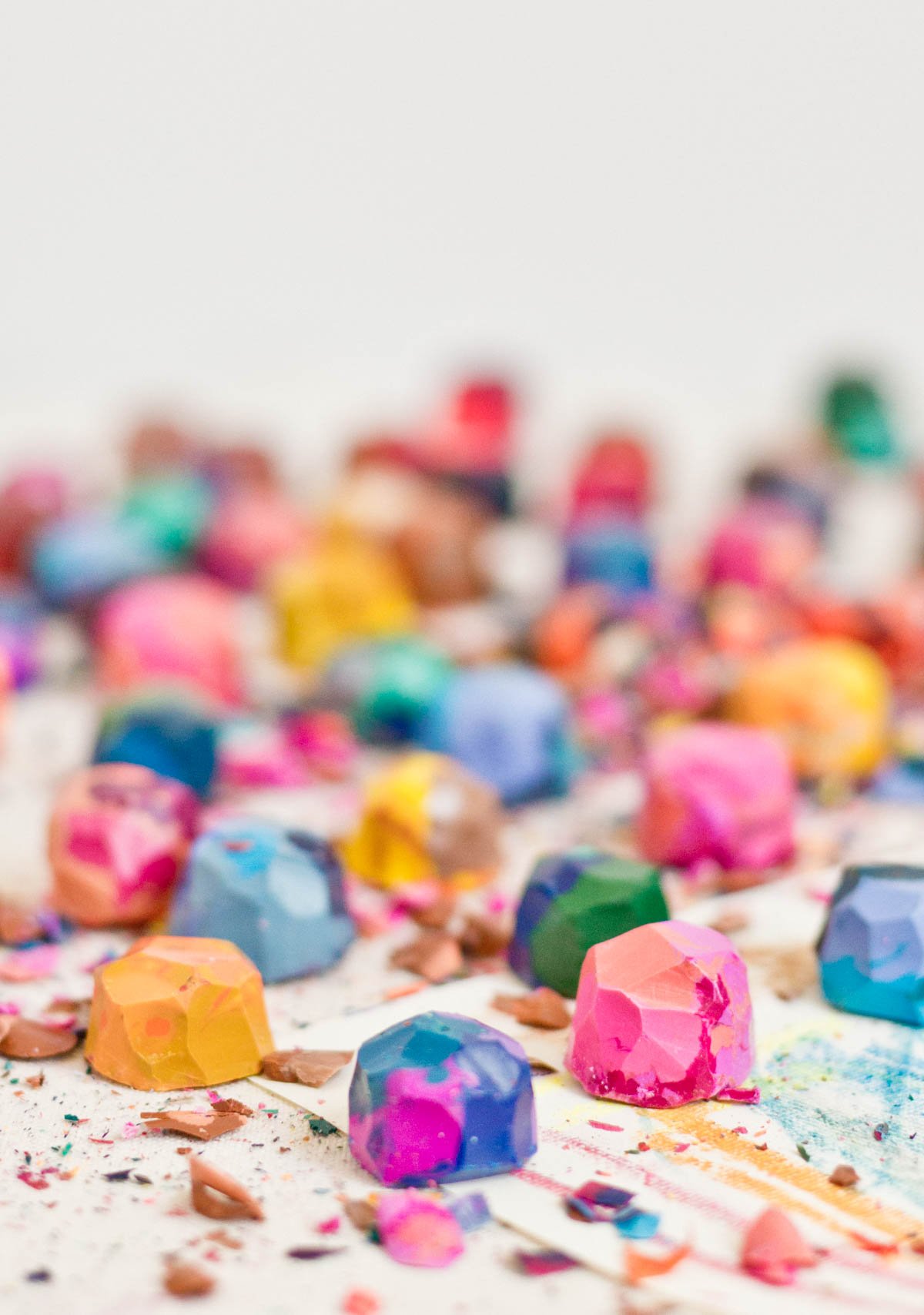 colorful crayons in rainbow colors with crayon shaving laying on desk