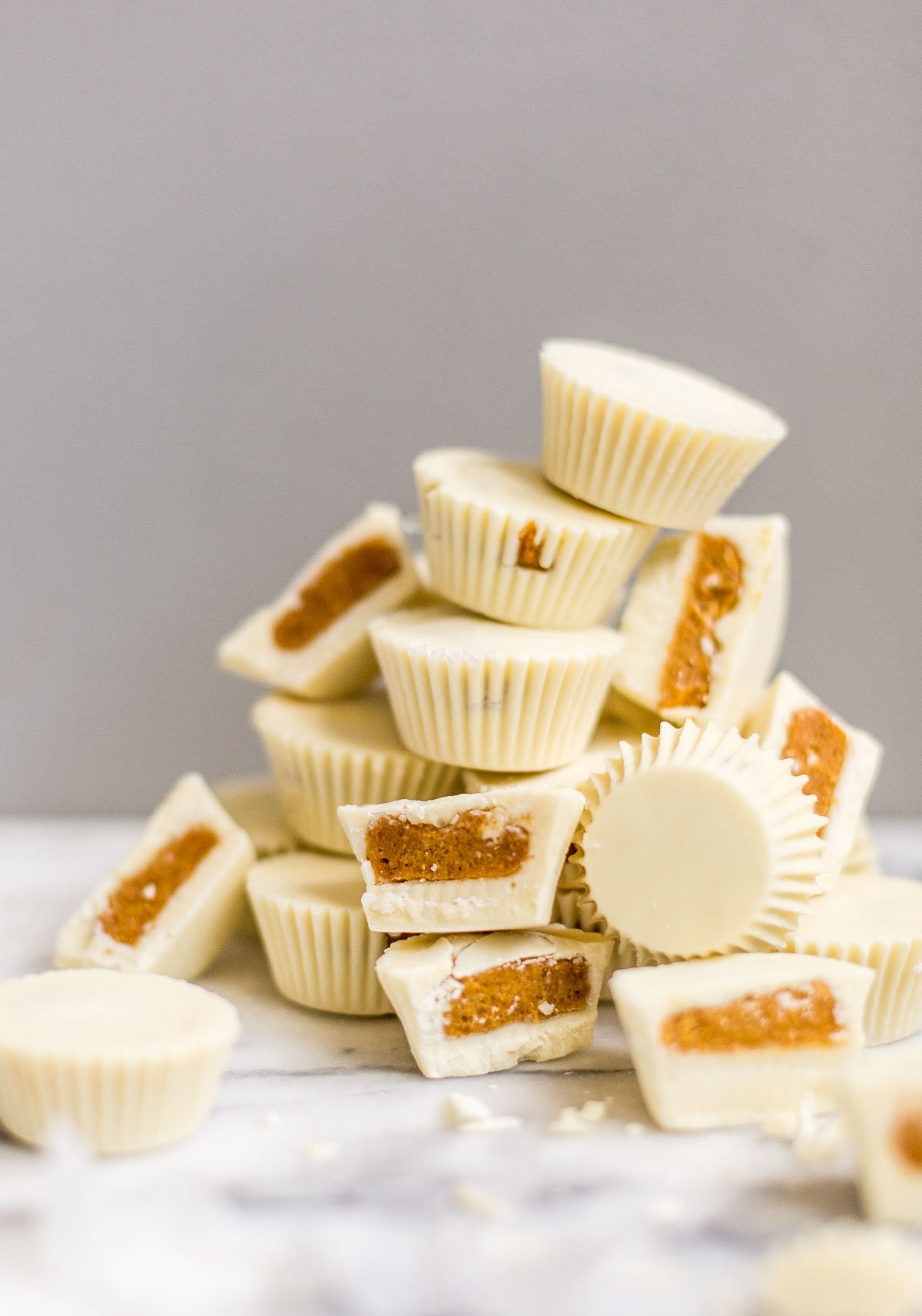 stacked pumpkin candy cups on a marble counter