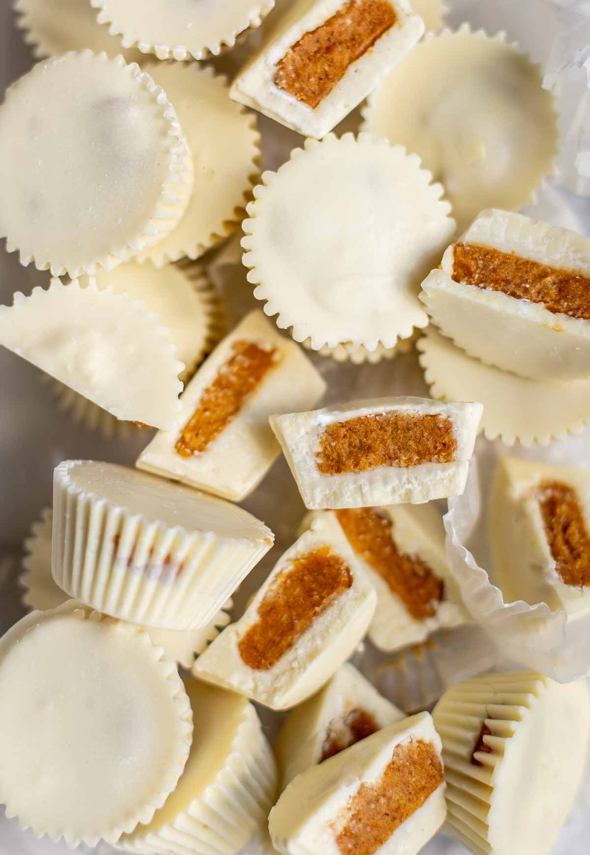 pile of white chocolate pumpkin pie candy cups overhead and broken into pieces