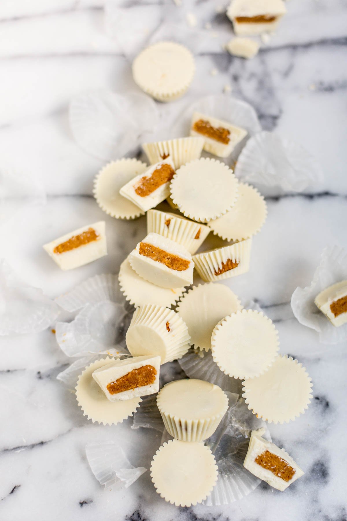 pumpkin pie candy cups with white chocolate laid out on a marble countertop