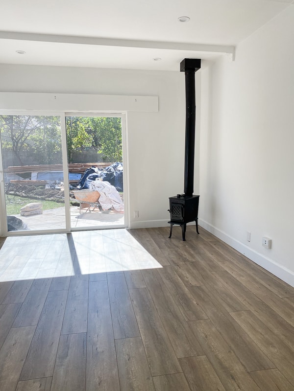 Before photo of empty bedroom with sliding doors that lead outside.