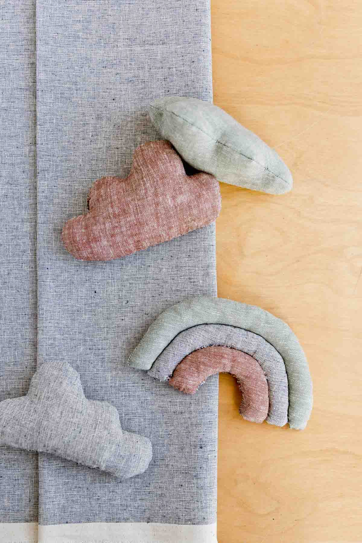 neutral plush toys for kids, made of fabric in various cloud and rainbow shapes