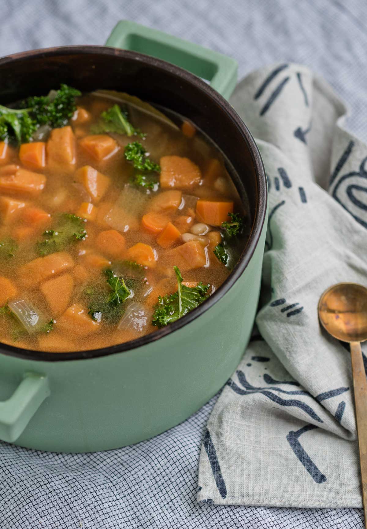 white bean and greens soup in green pot