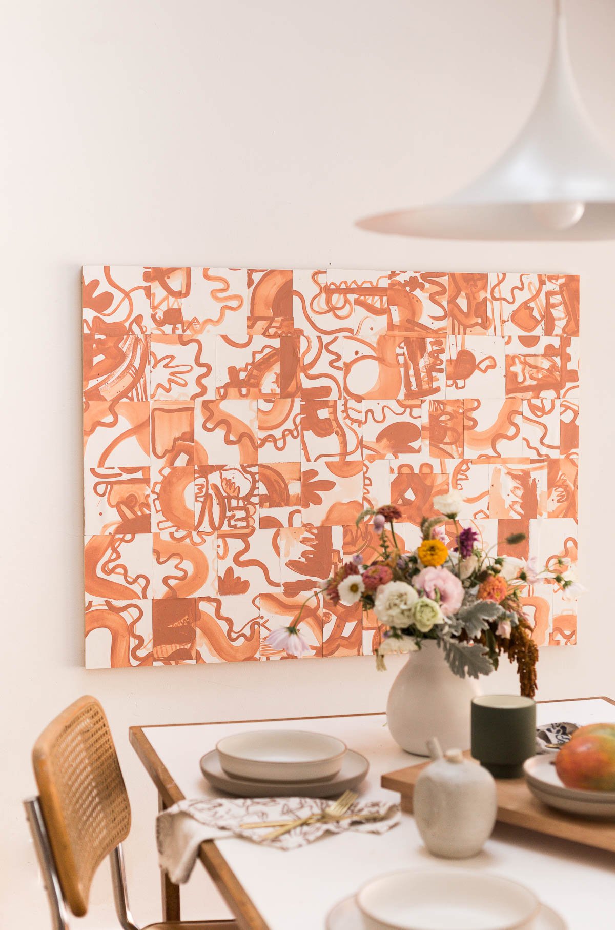 large scale abstract artwork with organic shapes in warm tones, hanging in all white dining room