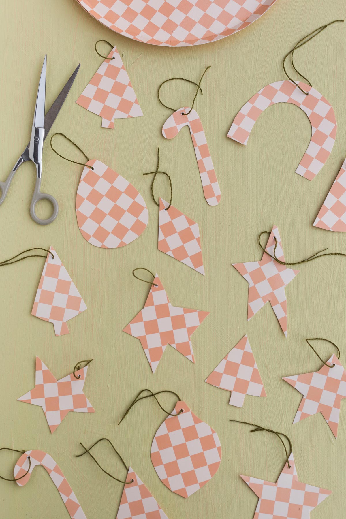 homemade checkered pattern paper ornaments on a green counter