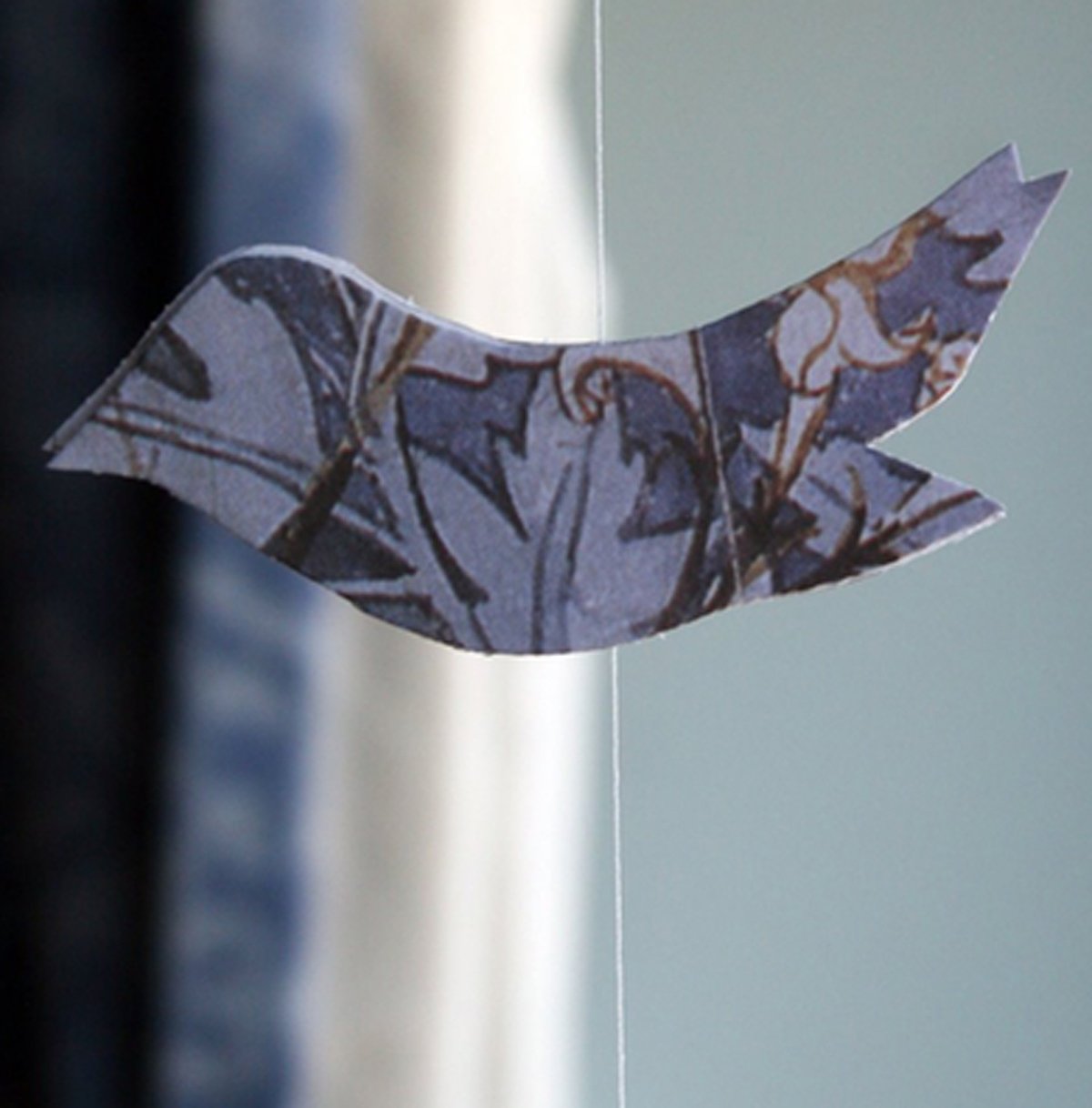 Closeup detail of recycled paper shaped like a bird and turn into a hanging mobile
