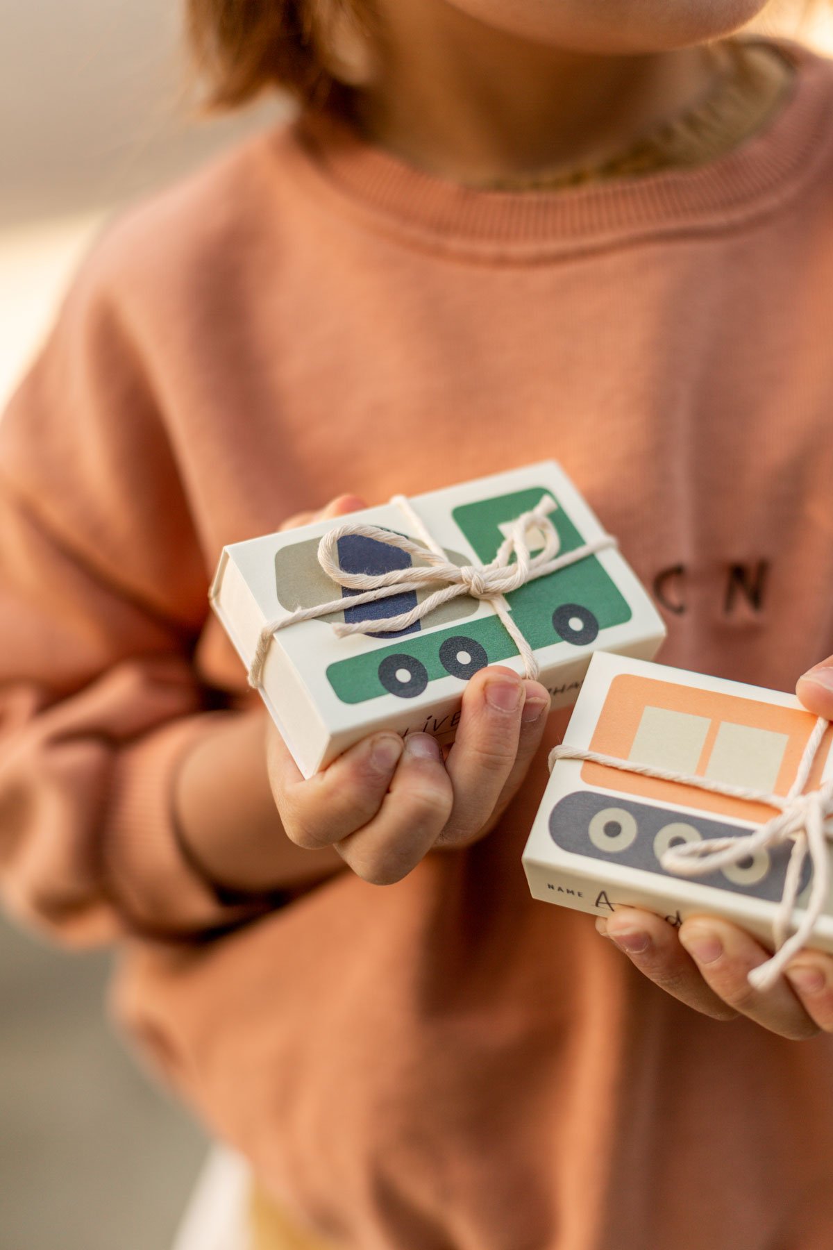 young boy holding construction themed valentines day gifts for his classroom