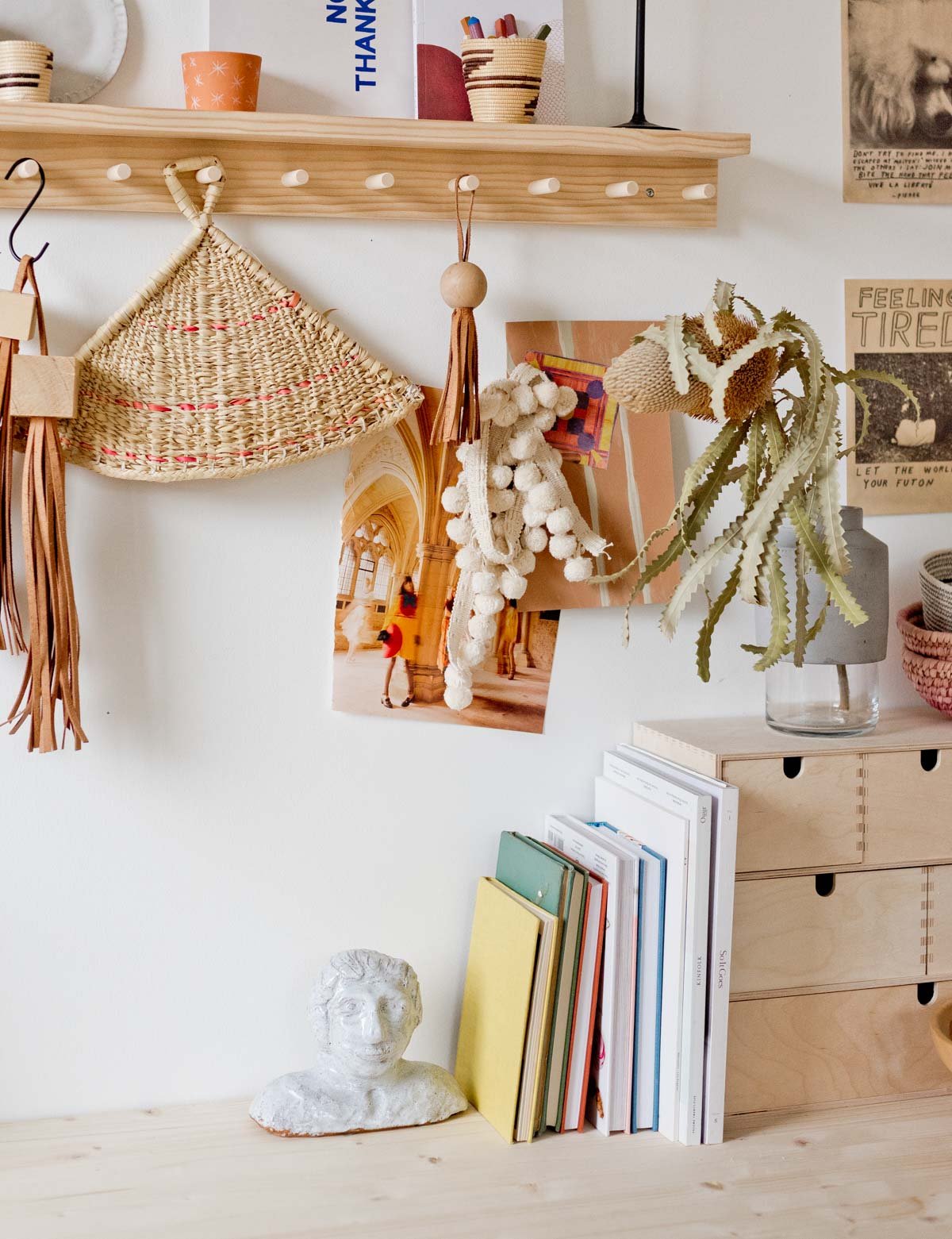 work from home desk space with wall hooks and artful items hanging from the peg rails