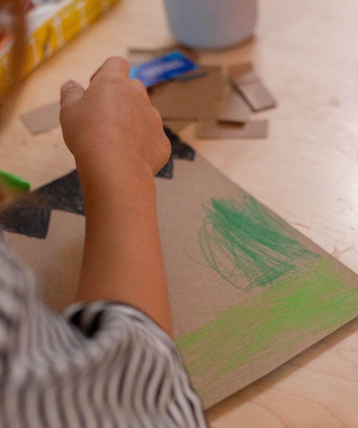 child coloring a piece of cardboard to make a halloween dry erase board
