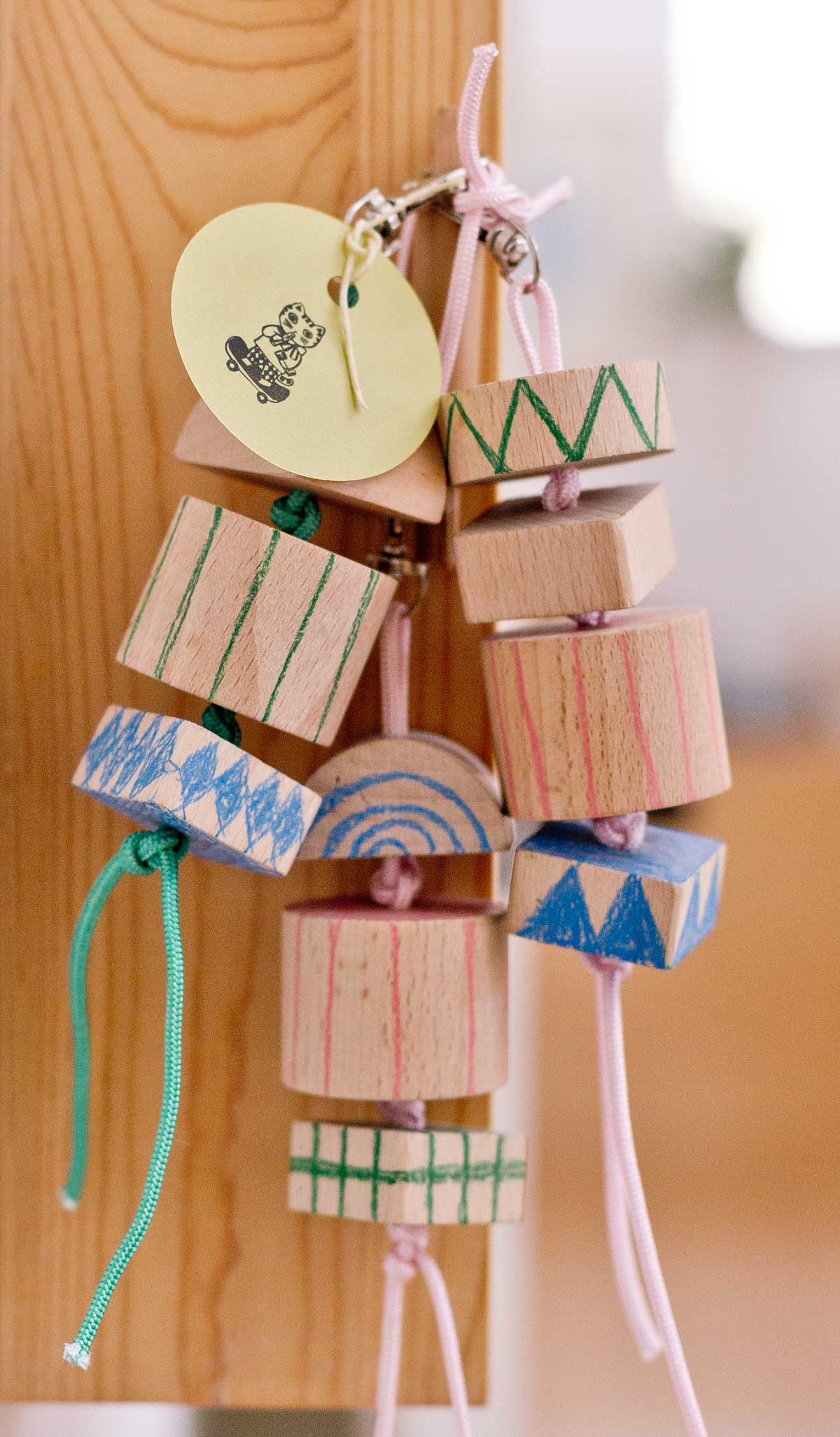 chunky keychains made from geometric wood blocks with hand drawn designs