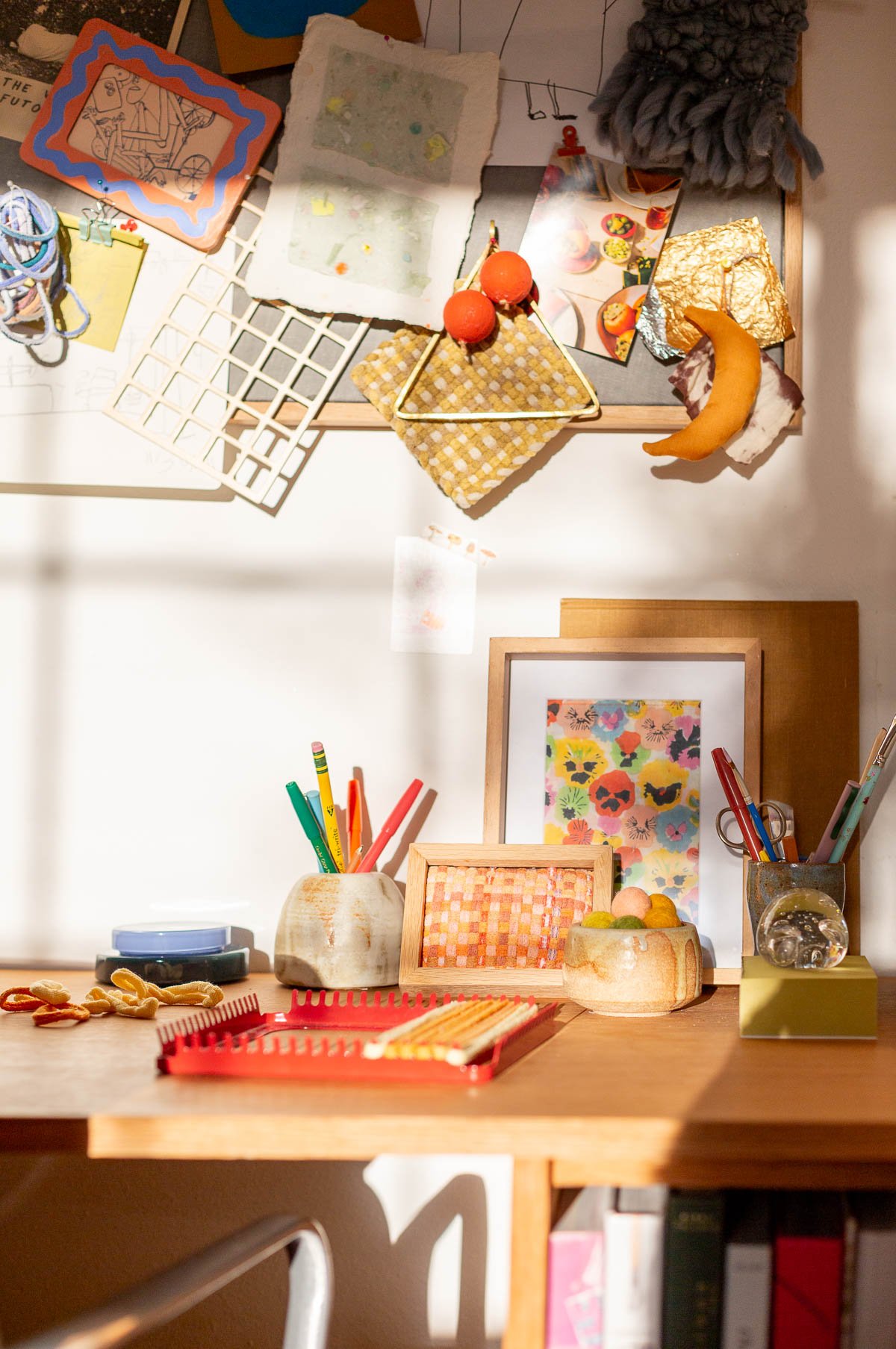 crafting space with desk and bulletin board in wood and colorful accessories