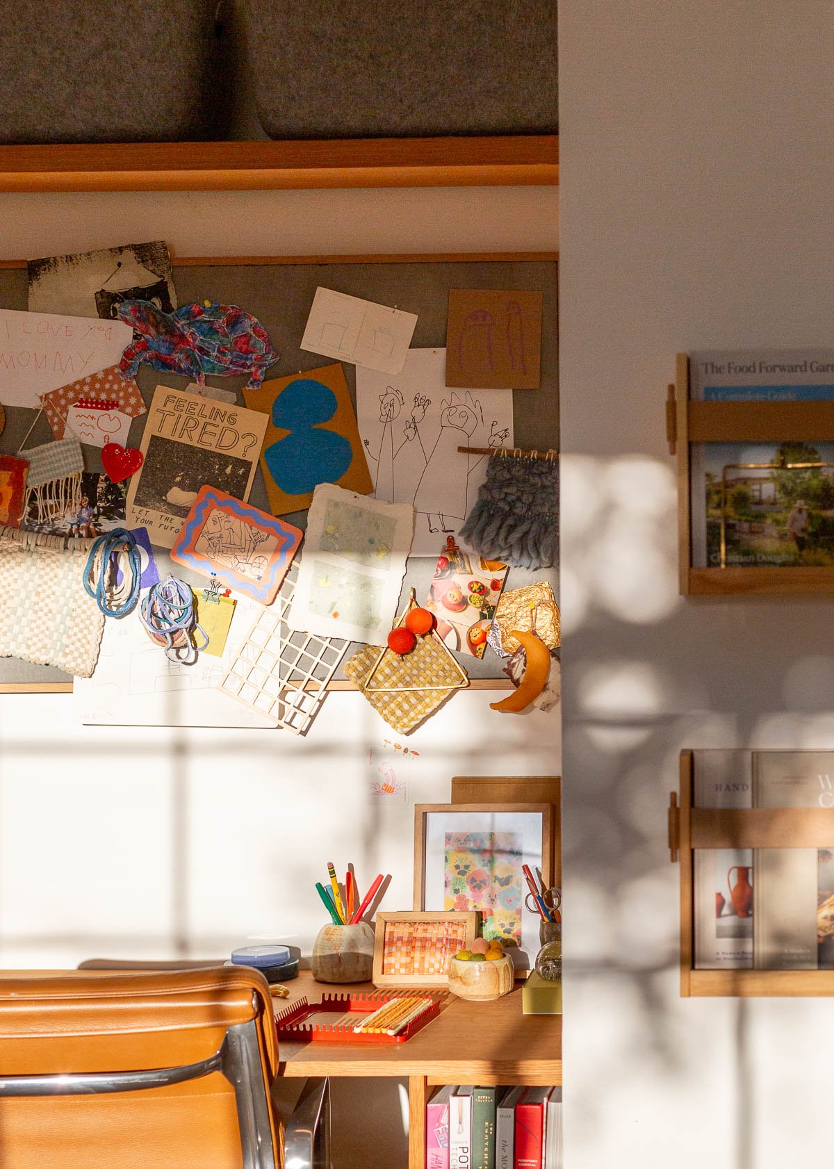 artsy cluttered wood desk and office space in a small closet