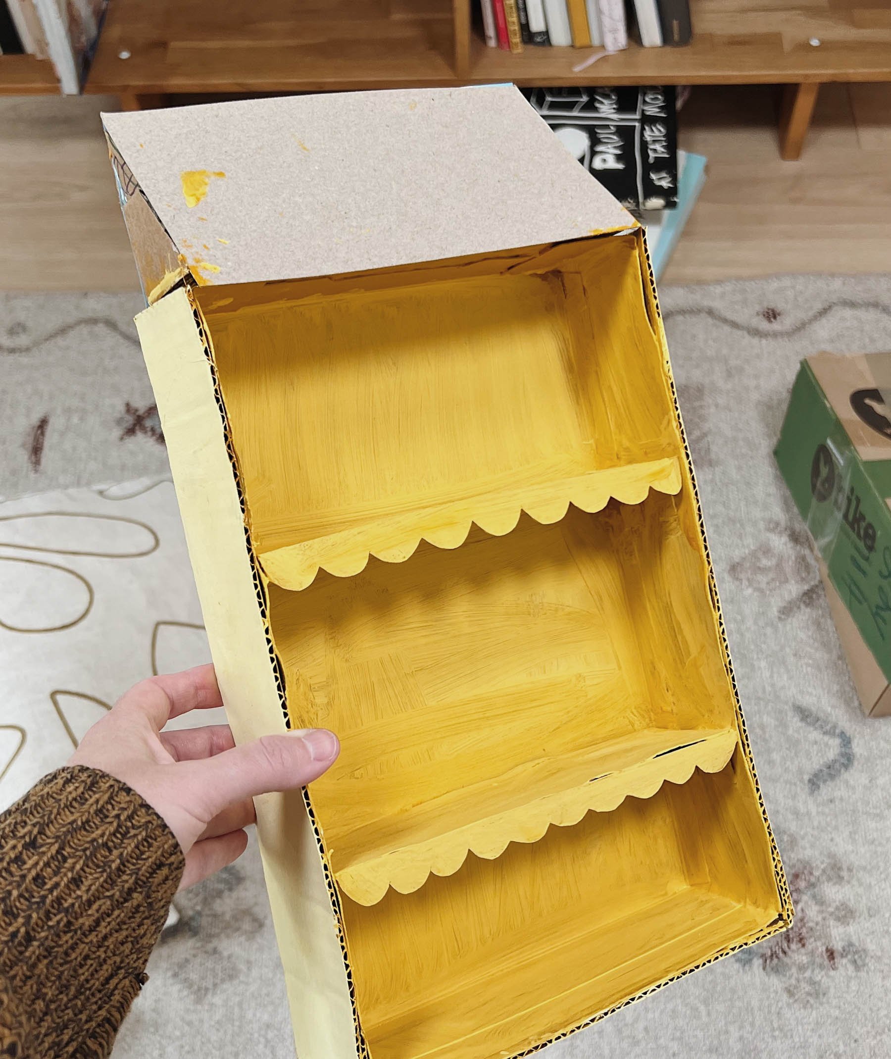 painting cardboard to make a dollhouse with shelves for a kids room