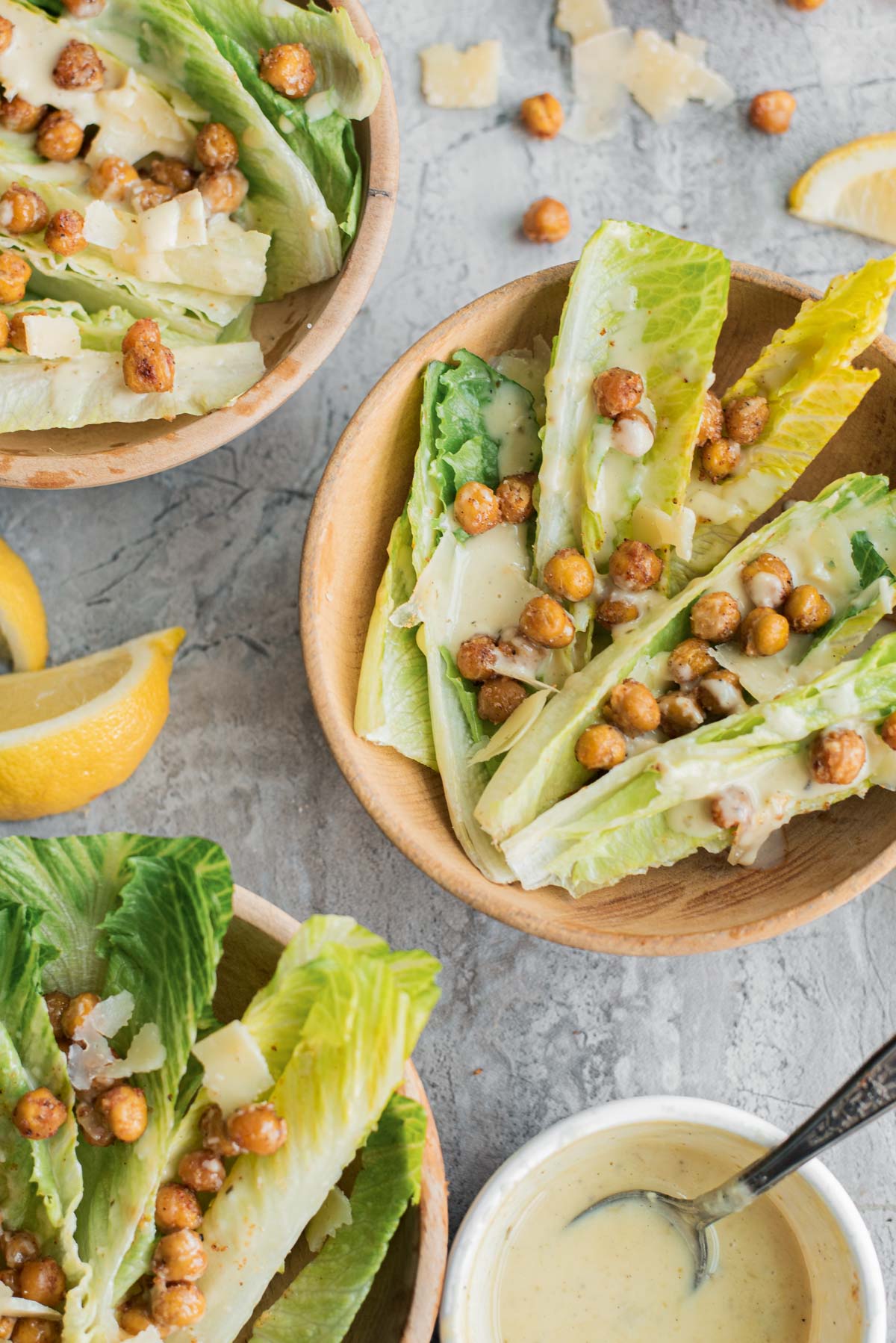 romaine lettuce and roasted chickpeas salad in small bowls with lemon slices
