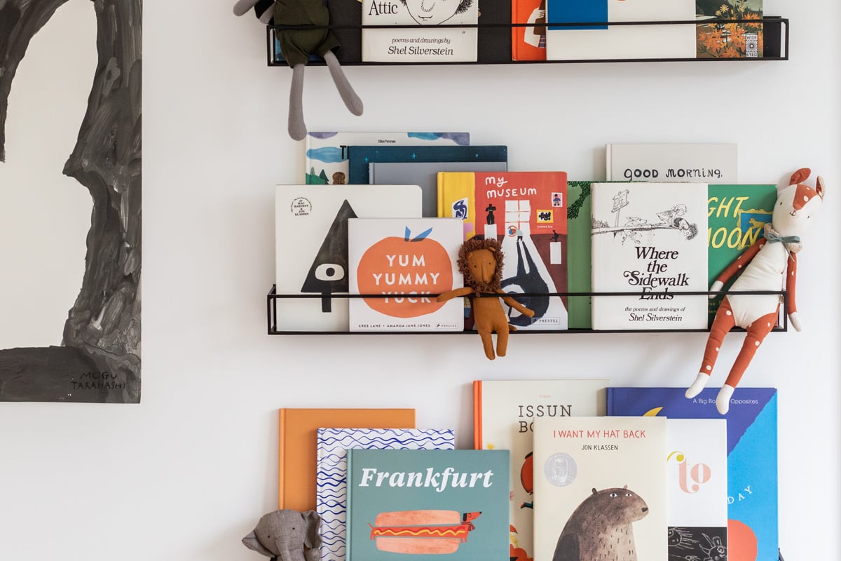 metal floating shelves filled with kids books and toys