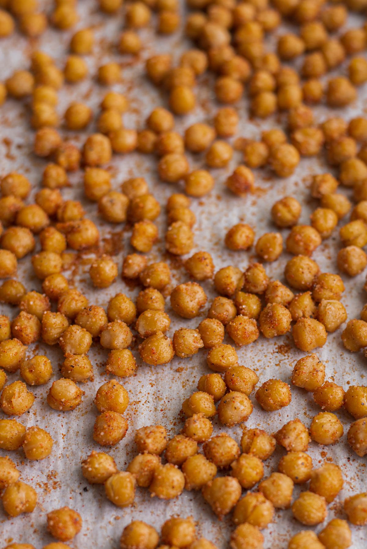 crispy roasted chickpeas straight from the oven, on a baking sheet with seasoning 