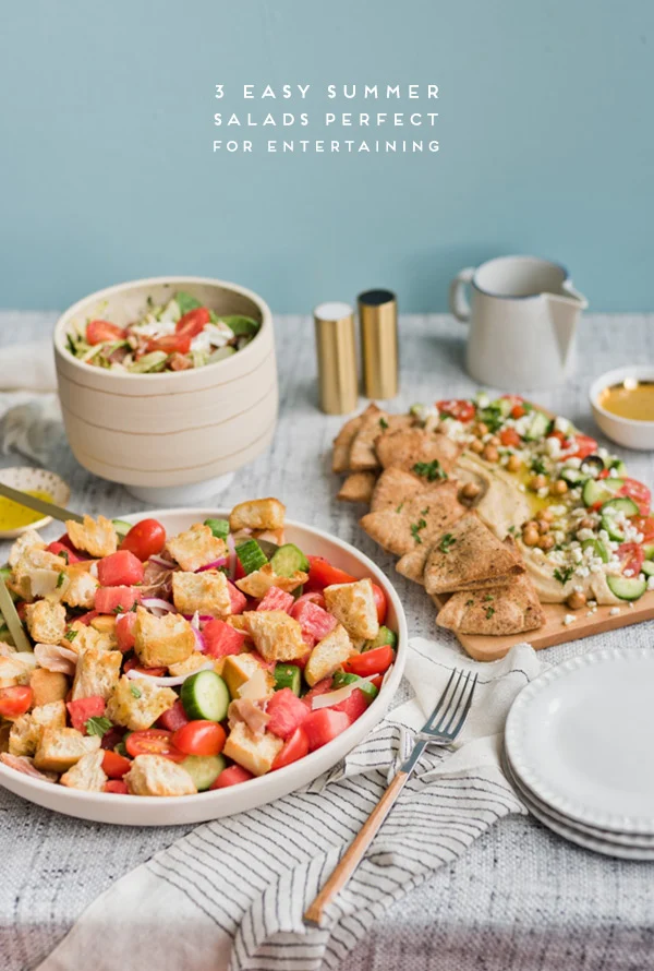 Three salads featuring different veggies and fruit on a table