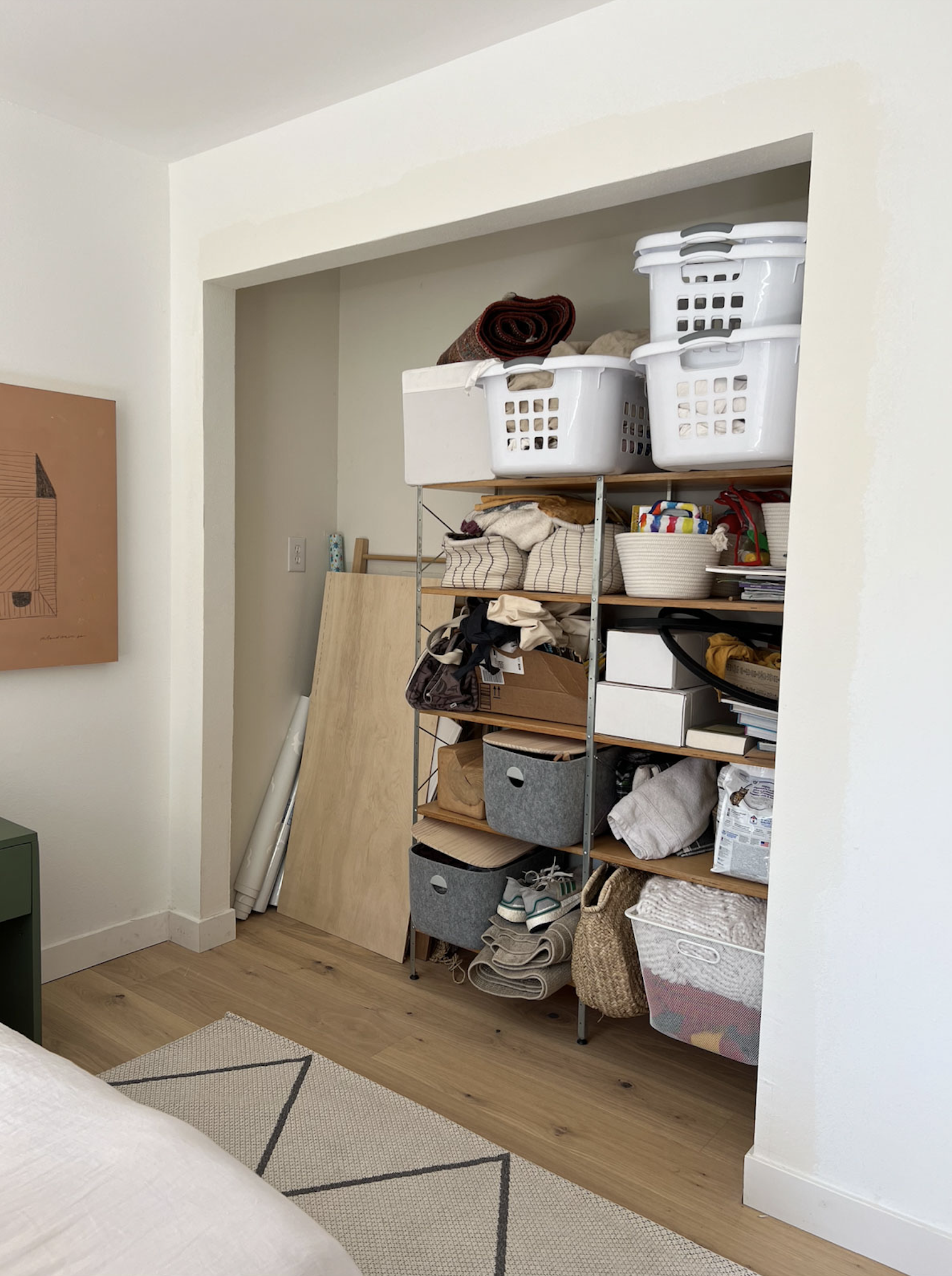 packed closet in a guest bedroom with no closet doors