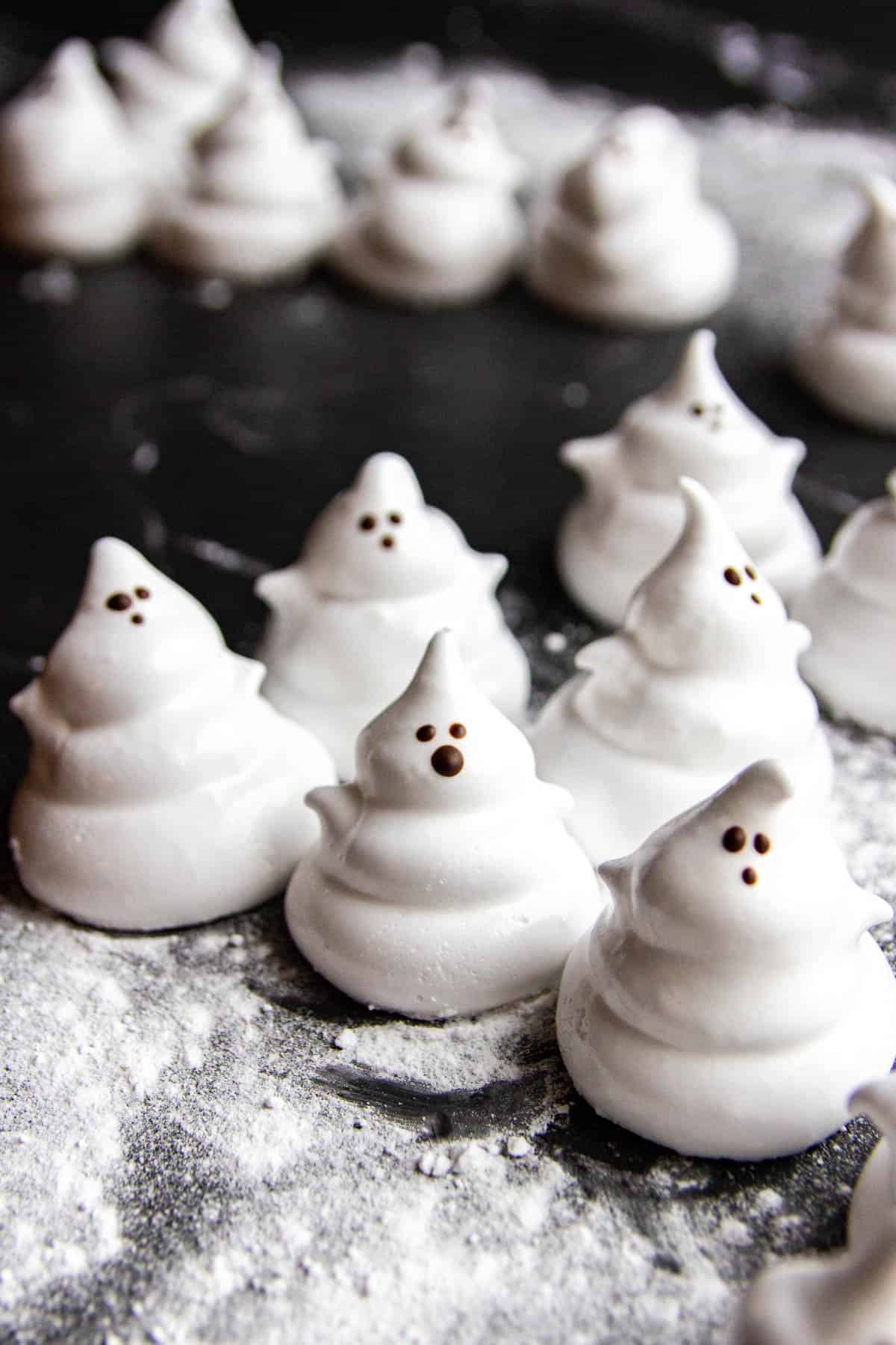 marshmallow halloween treats that look like ghosts with tiny chocolate faces
