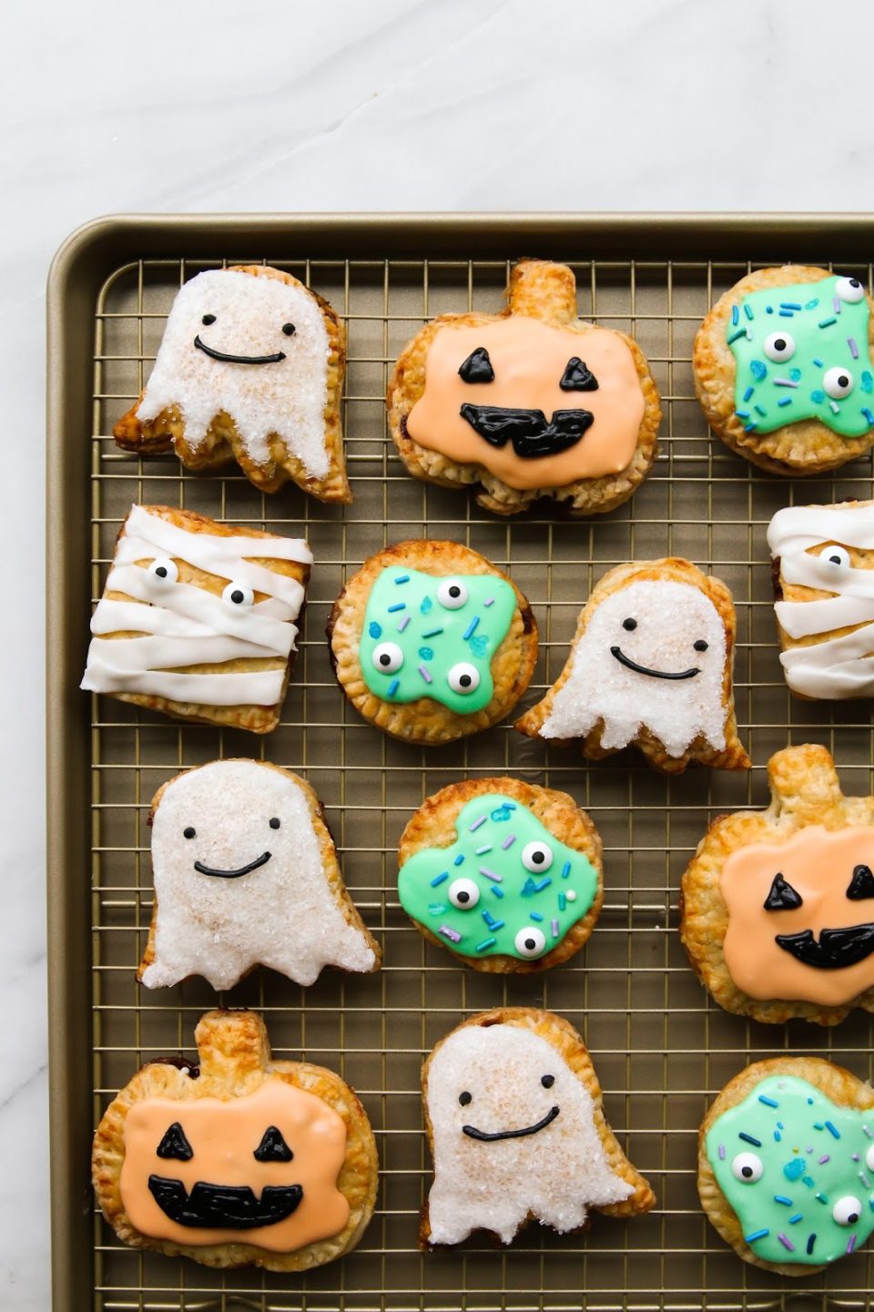 cute halloween baked good pop tarts in ghost, monster, and pumpkin shapes