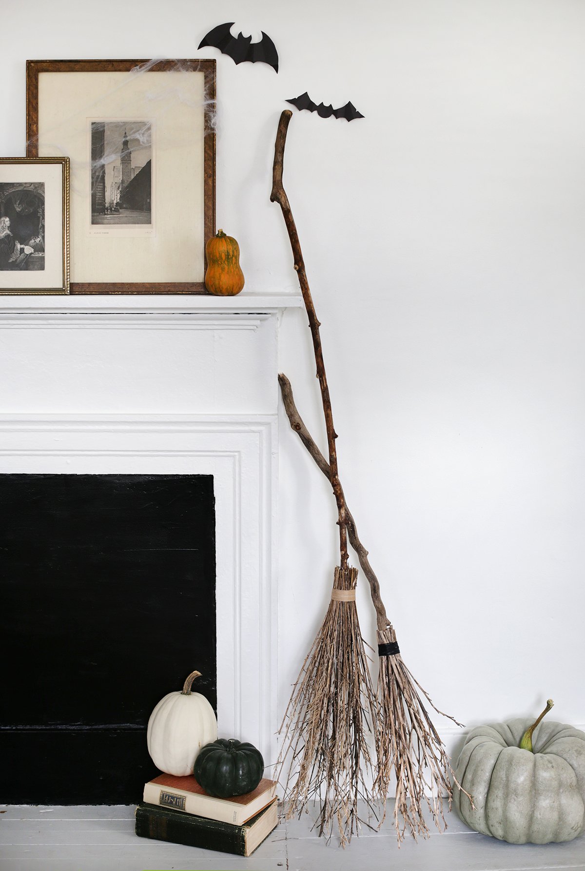 2 DIY brooms leaning against a fireplace fro Halloween