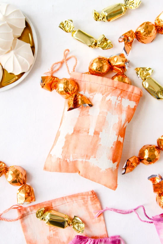 tie dyed orange canvas treat bag with candy coming out of the bag
