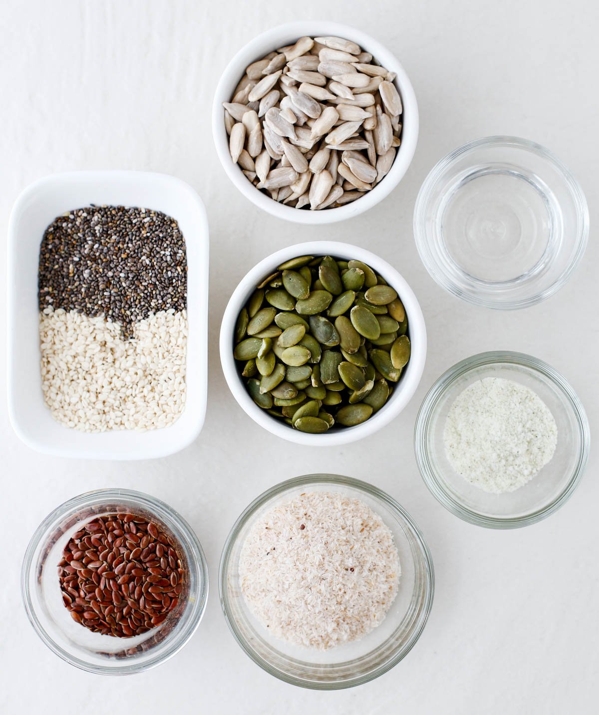 ingredients for making homemade seed crackers, each ingredient is in a different bowl