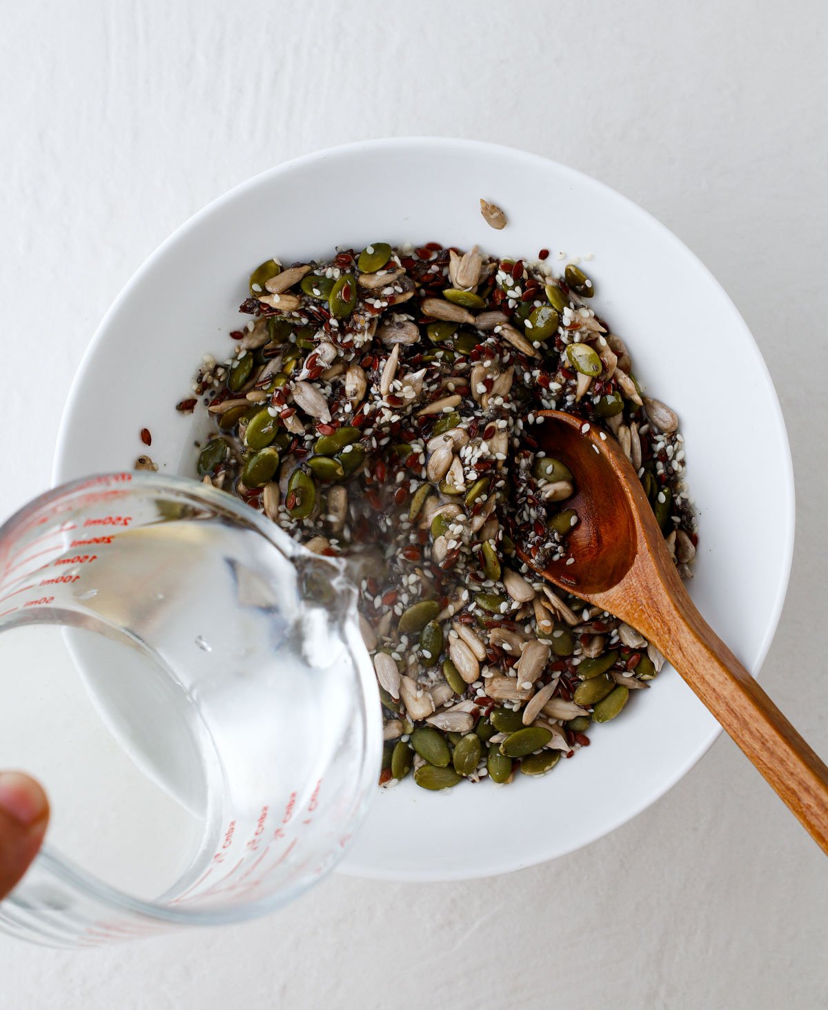 mixing seeds and other seed cracker ingredients in a bowl