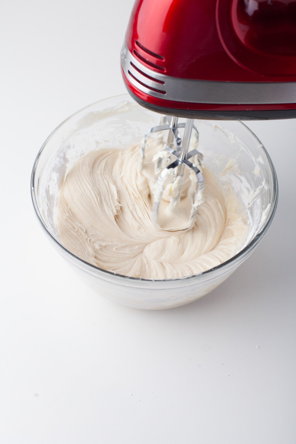 blending frosting with hand mixer