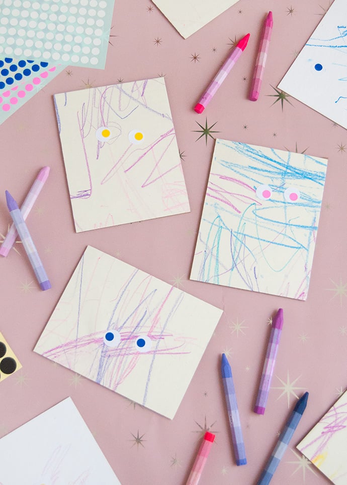 scribbles on paper from kids with eye shaped stickers on them to look like mini monster art