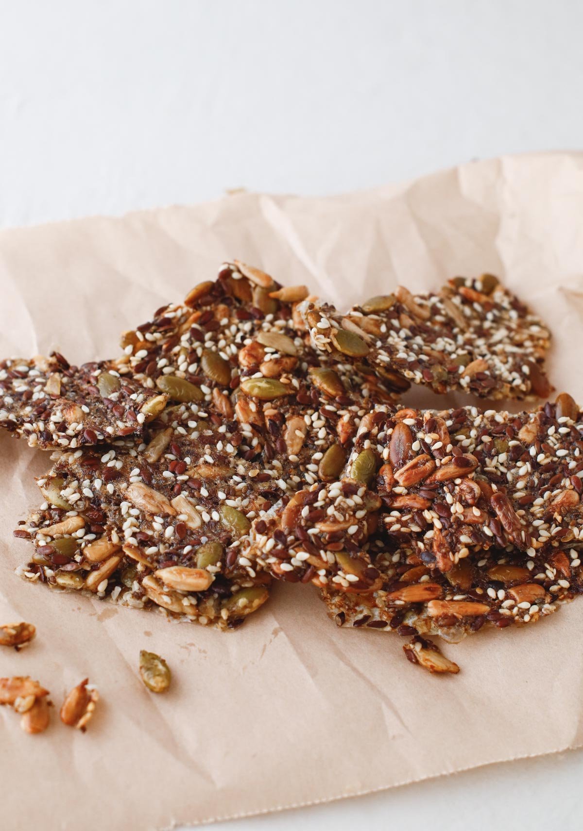 seed crackers stacked up in a small pile, on a brown piece of wax paper