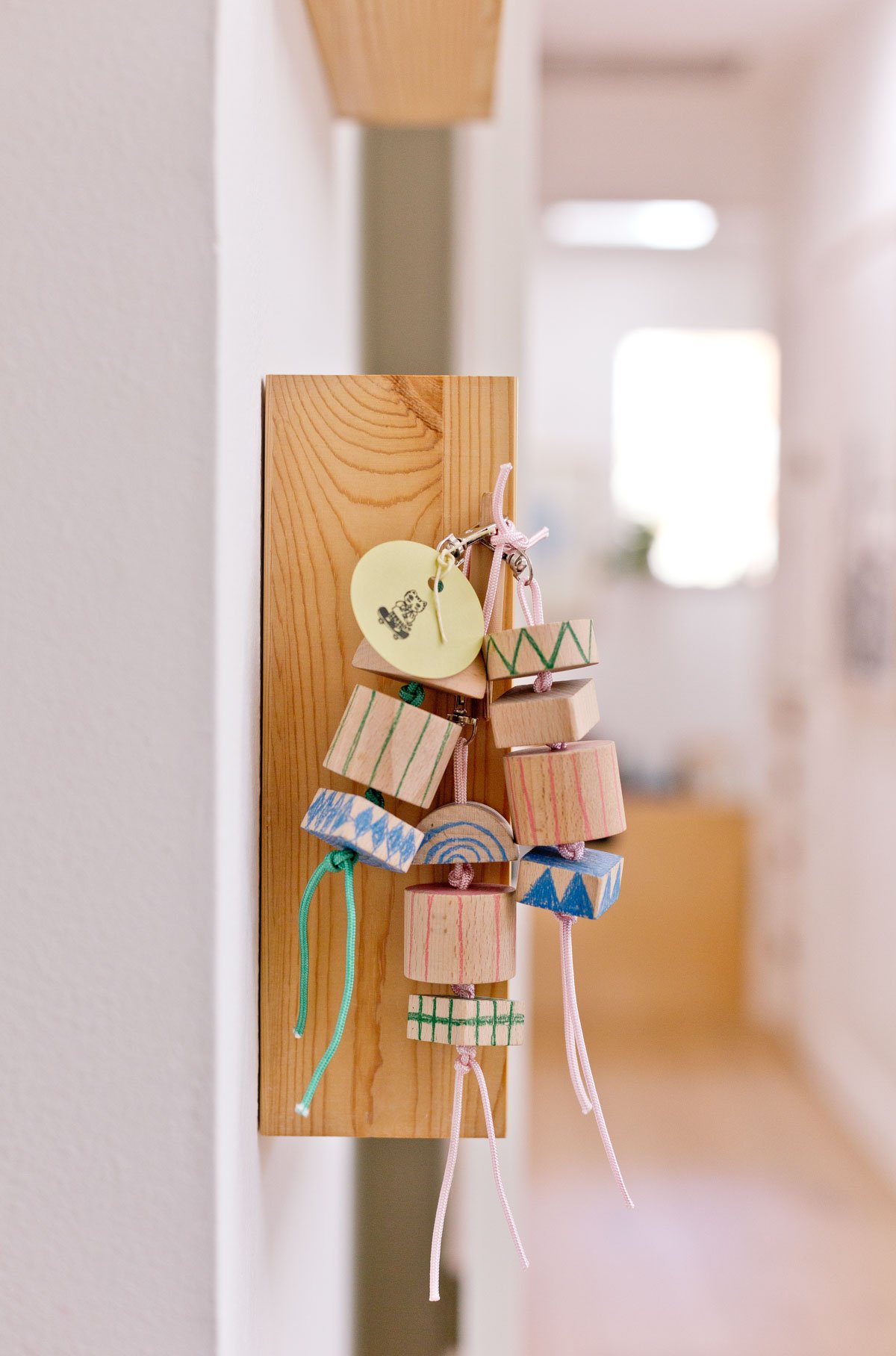 group of wood keychains hanging from a shelf 