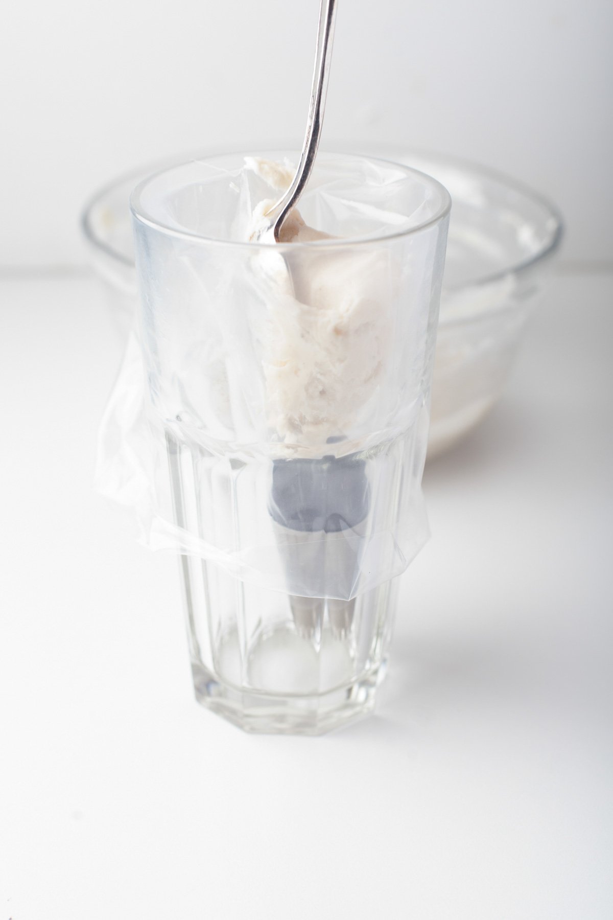 putting icing into a piping bag using the glass trick to make it easy to get the icing in