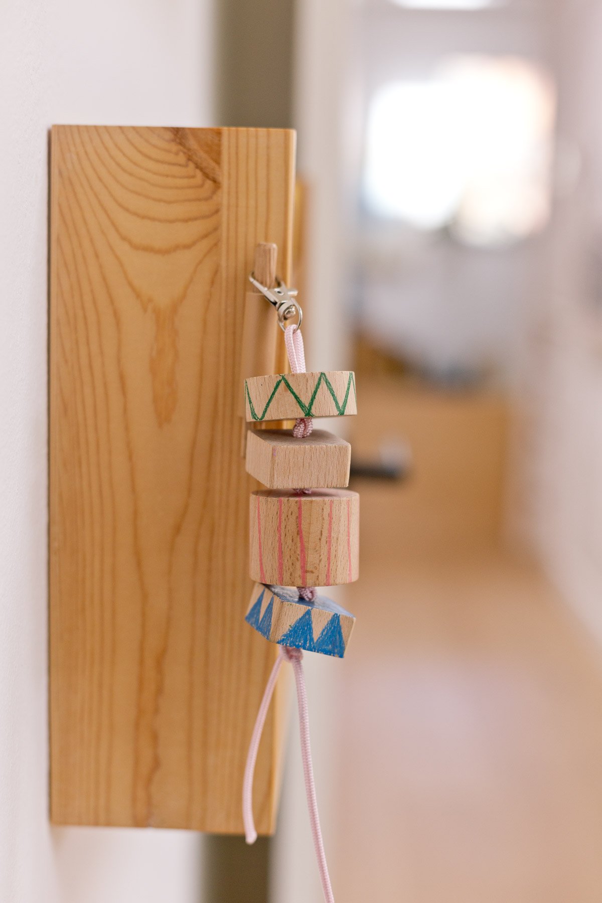 wood keychain hanging from wood shelf in a bedroom