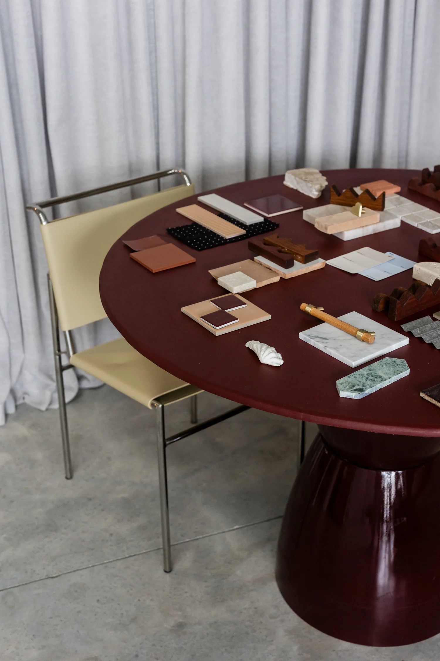 dark burgundy dining table in minimal modern dining room with papers and office supplies on it