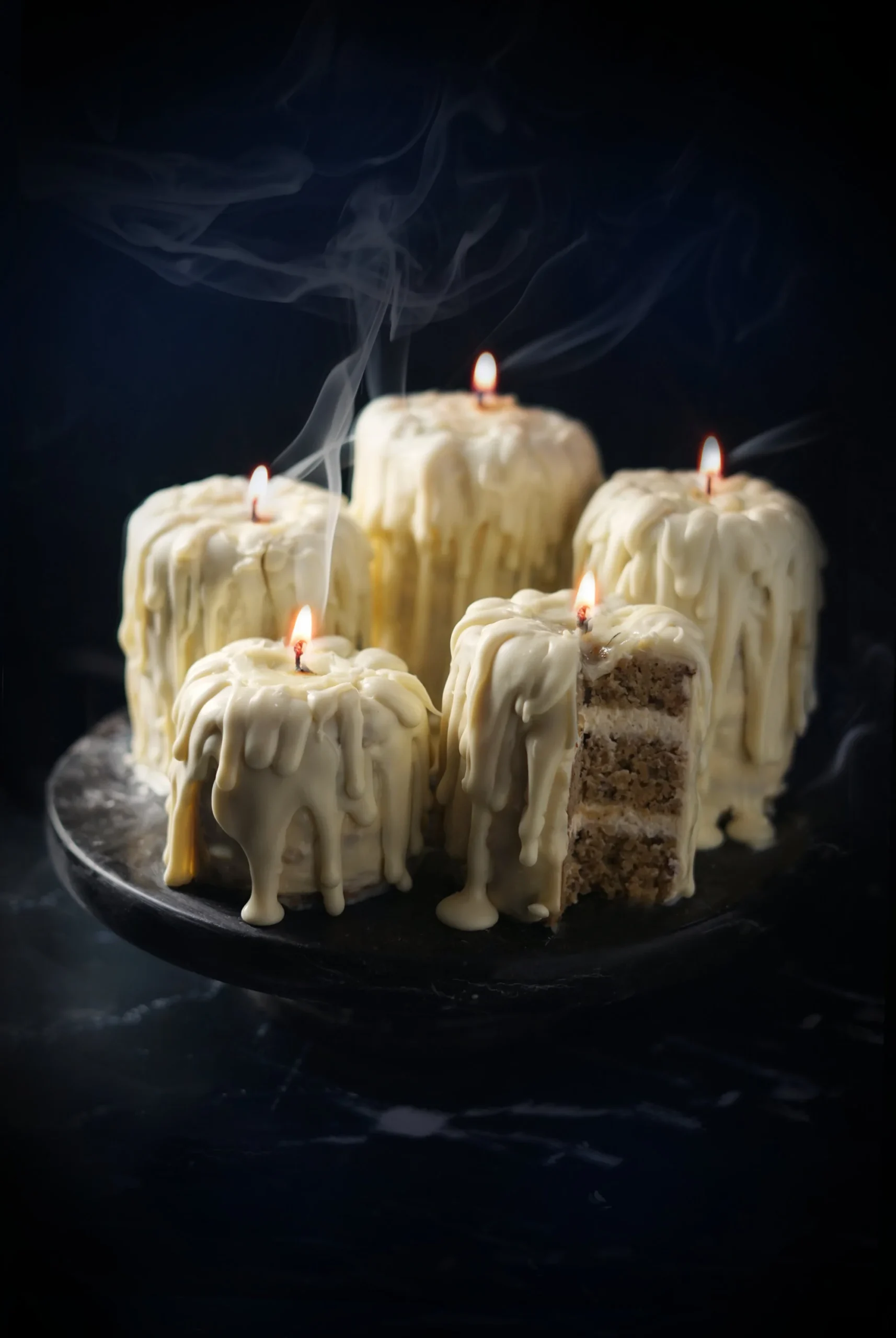 small cakes that are made to look like melting candles, with a wick in the middle they are all lit up