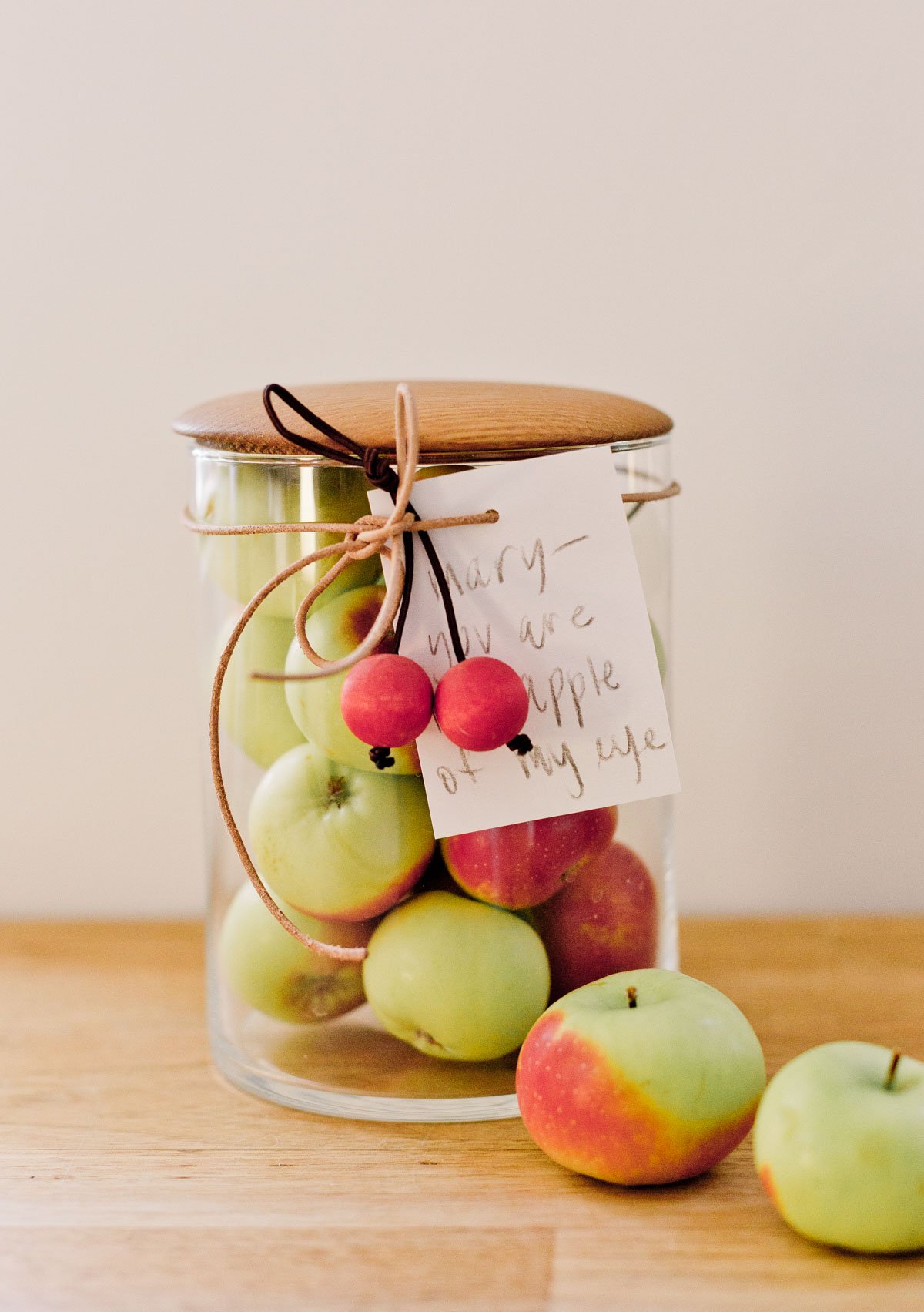 tiny apples, all in a glass jar with a handwritten note as a gift for the holidays
