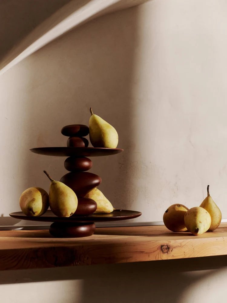 pears on a table with a statement dessert stand made of wood