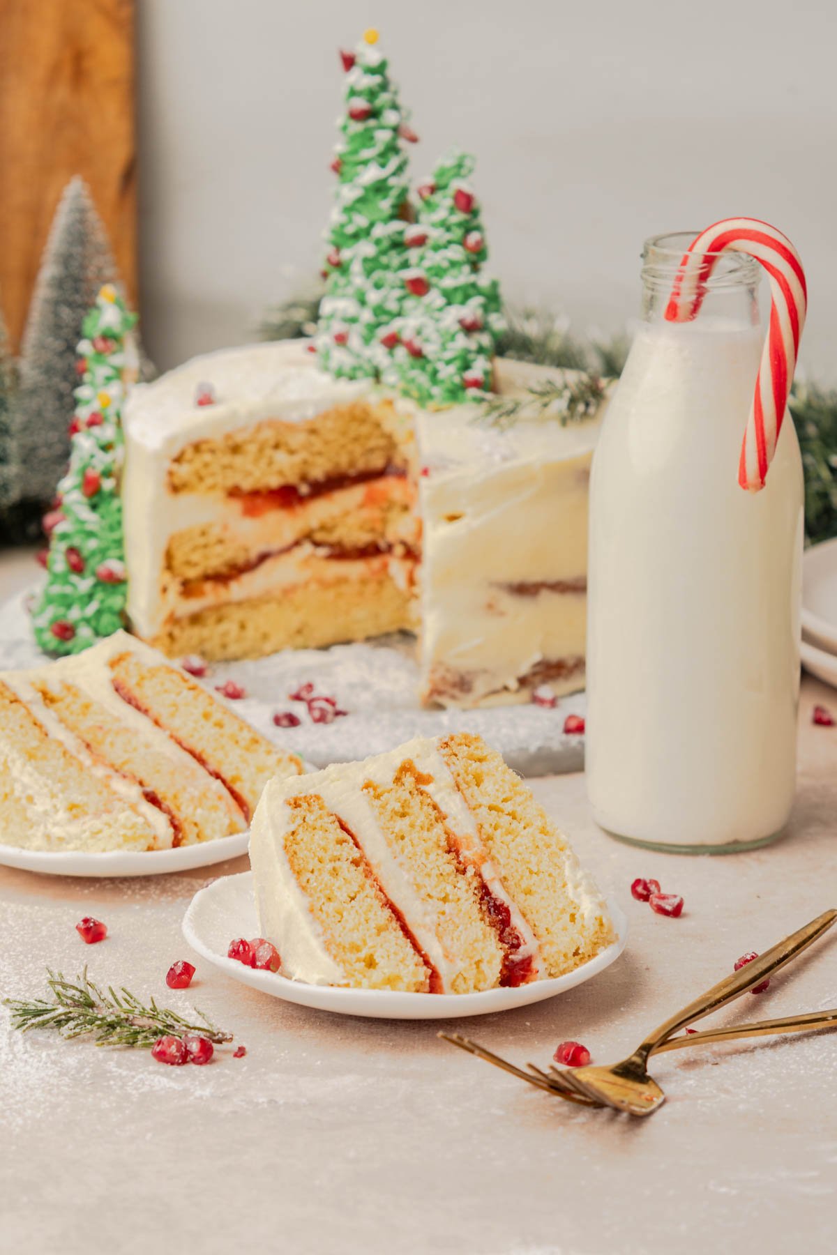 two slices of christmas cake with red cranberry filling and a glass of milk
