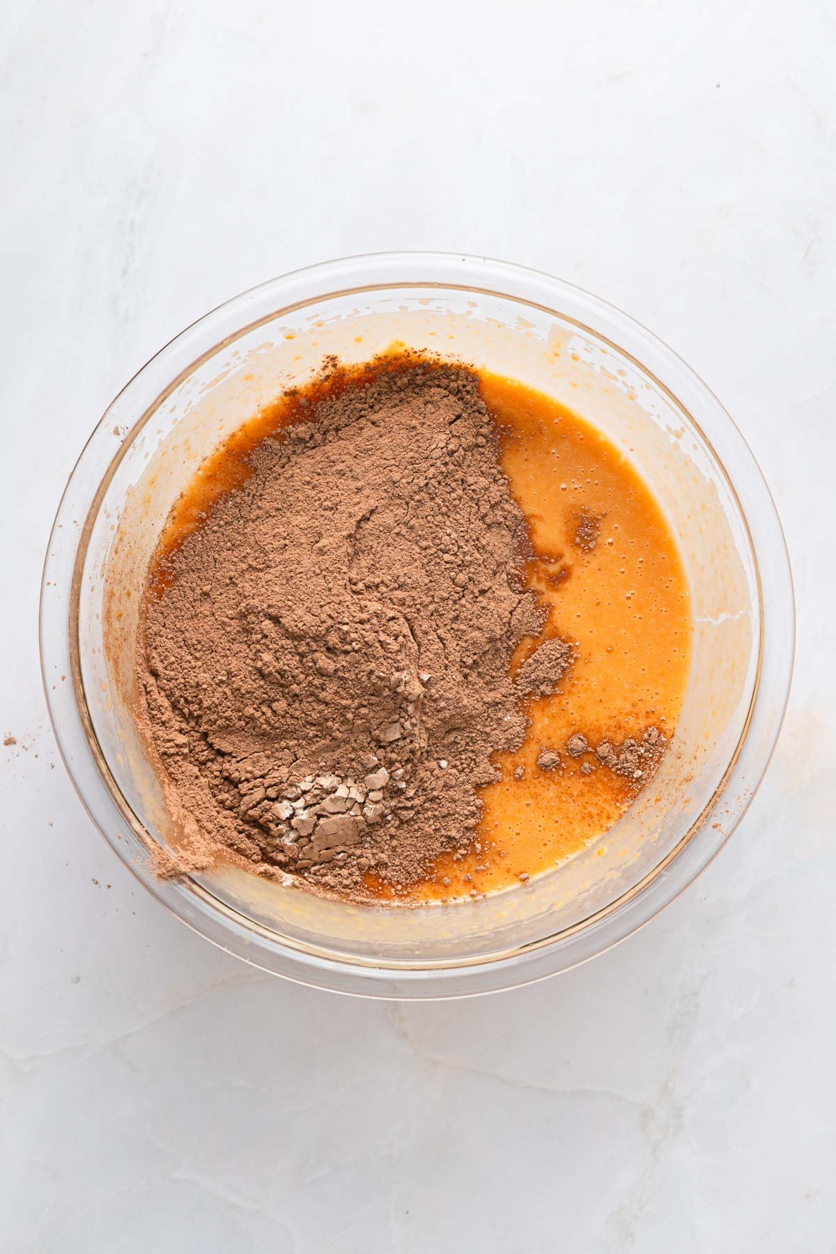 ingredients being mixed in a bowl for brownies, cocoa powder, sweet potatoes, and more