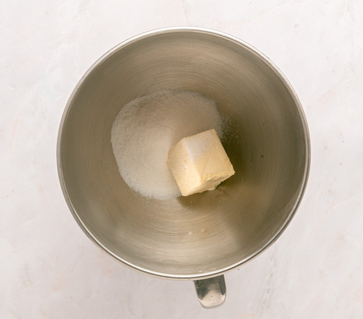 butter and sugar in a stainless steel bowl, ready to be mixed