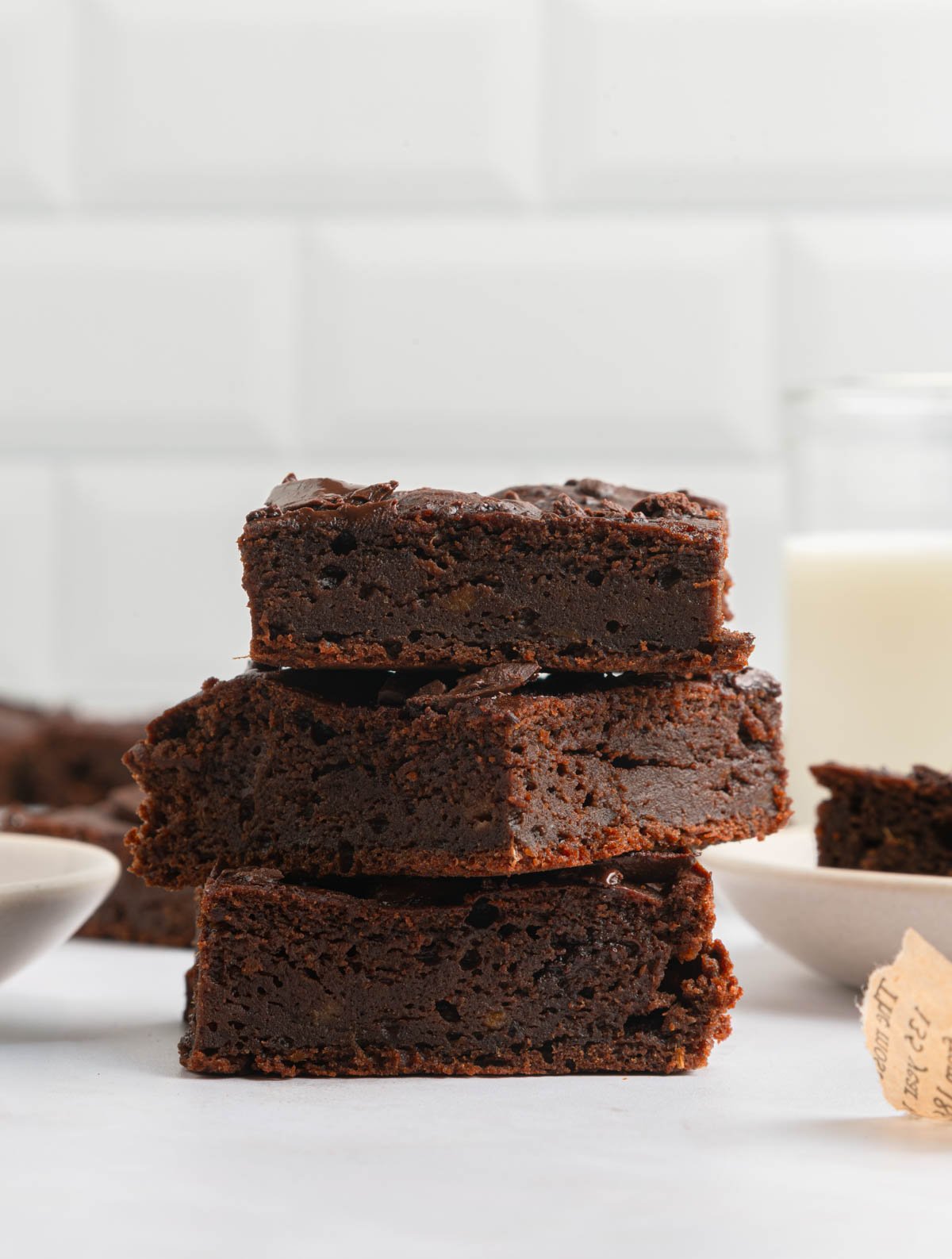 fudge-y rich brownies stacked on top of each other in a white kitchen