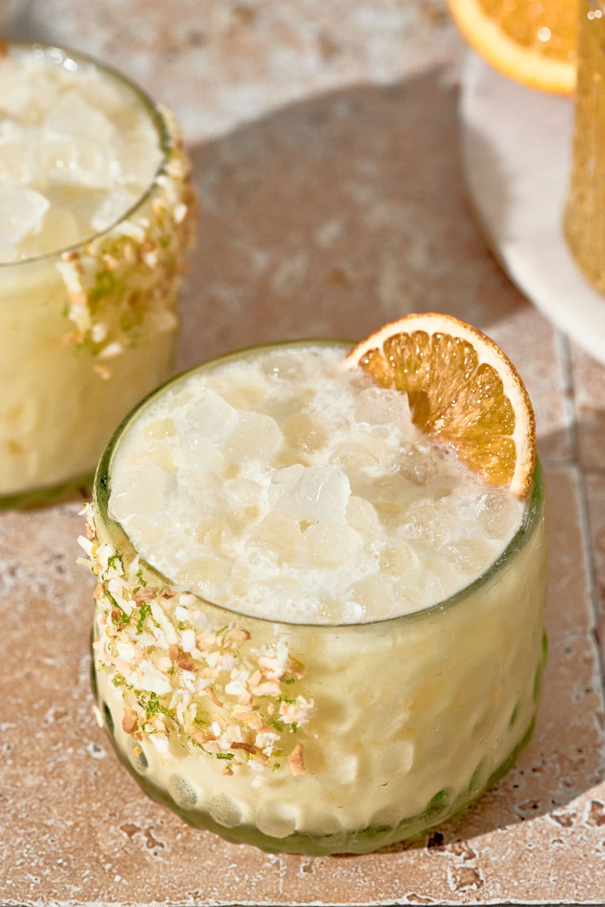 orange creamsicle summer cocktail with nugget ice, in a short glass, and orange slice garnish