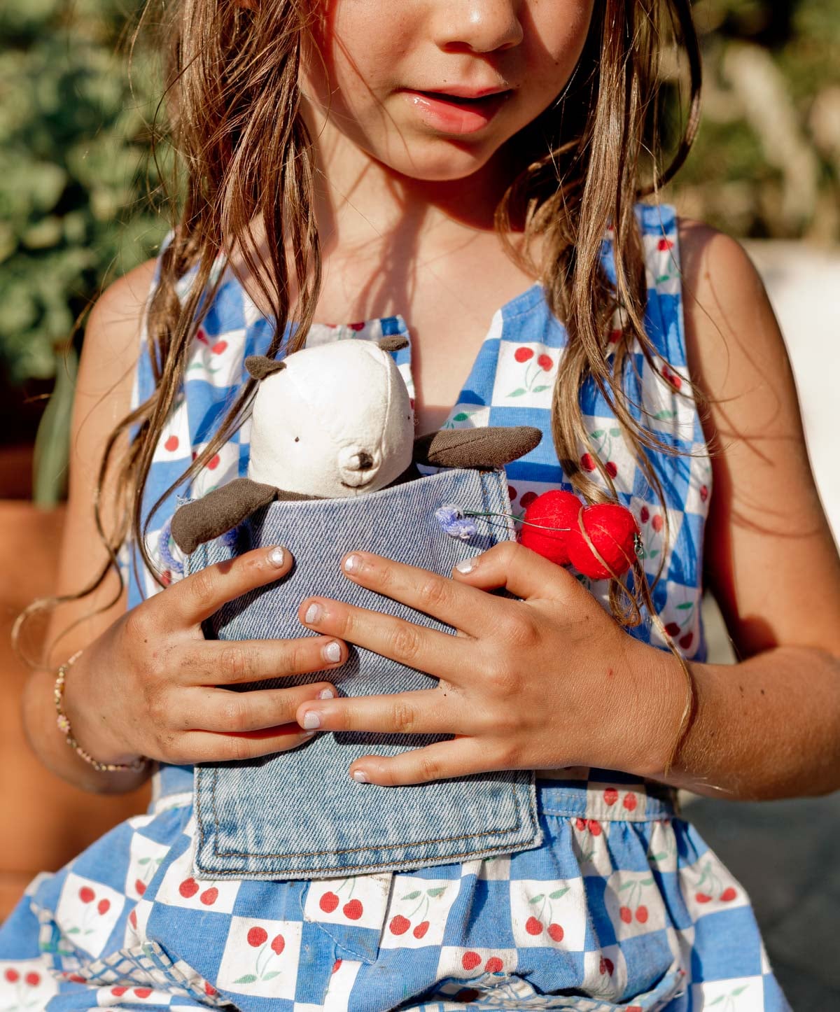 girl holding a denim purse pouch with a small stuffed panda inside