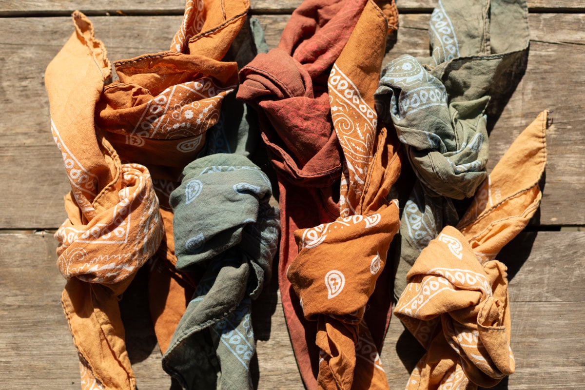 earth tone, neutral color bandanas on an old table outdoors